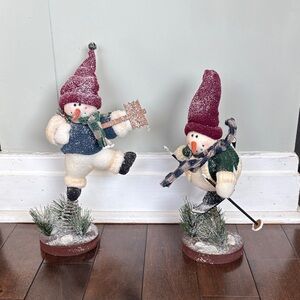 Vintage Christmas decor of snowman figurines on solid wood base with a spring